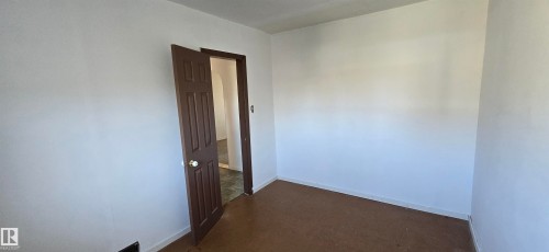 Room featuring white painted walls, brown door with white knob, and brown carpet flooring - Vegreville, AB - Indoor Photo Showing Other Room