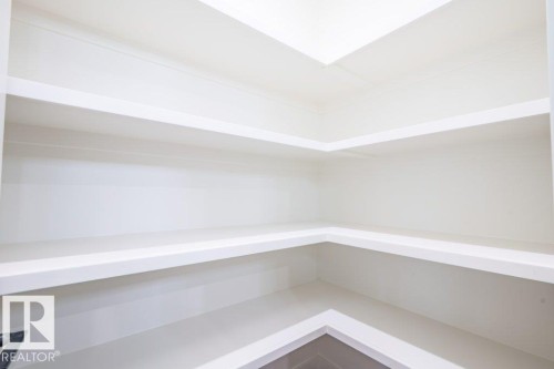 Built-in shelving featuring a clean white finish, multiple storage levels, and a corner configuration - 5211 104A Street, Edmonton, AB 