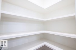 Built-in shelving featuring a clean white finish, multiple storage levels, and a corner configuration - 