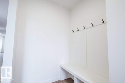 Built-in mudroom bench with cubby storage and black coat hooks - 5211 104A Street, Edmonton, AB 