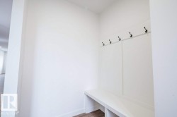 Built-in mudroom bench with cubby storage and black coat hooks - 