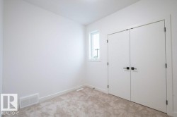 Room featuring plush carpet flooring, white walls, a single window, and a double-door closet with matte black hardware - 
