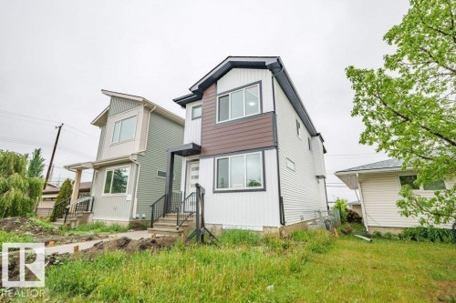 Contemporary two-story exterior with white siding and dark accent paneling - 5211 104A Street, Edmonton, AB 