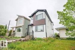 Contemporary two-story exterior with white siding and dark accent paneling - 