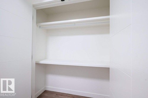 Recessed wardrobe with a hanging rod and two integrated shelves, finished in white - 5211 104A Street, Edmonton, AB 
