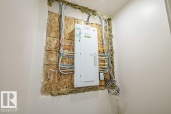 Electrical panel and exposed wiring installation against an OSB board - 