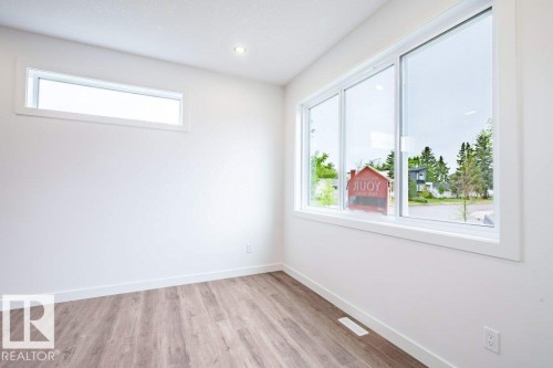 Bright room featuring wood-finish flooring and white baseboards - 5211 104A Street, Edmonton, AB 