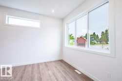 Bright room featuring wood-finish flooring and white baseboards - 