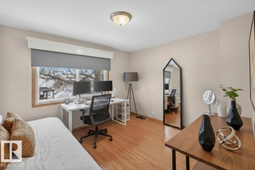 Hardwood flooring, neutral wall tones, window with gray roller shade, white crown molding, and flush-mount ceiling light - 14648 54 Street, Edmonton, AB 