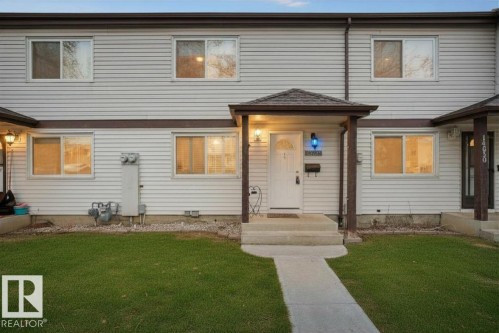 Townhome exterior featuring light-colored horizontal siding and dark trim - 14648 54 Street, Edmonton, AB 