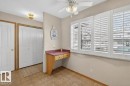 Built-in desk area featuring a red countertop and light wood-finish cabinetry - 14648 54 Street, Edmonton, AB 