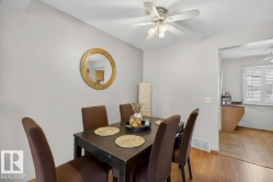 Dining area featuring wood-finish flooring, a ceiling fan with integrated lighting, and neutral wall tones - 