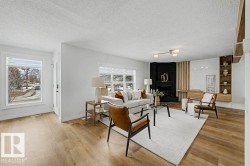 Living room featuring wood-finish flooring, white walls, and recessed lighting - 