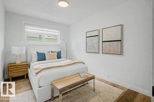 Crisp white walls frame a room featuring wood-finish flooring, a contemporary flush-mount ceiling light, and a window with white blinds - 49 Galloway Drive, Sherwood Park, AB - Indoor Photo Showing Bedroom