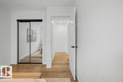 Bright hallway featuring wood-finish flooring, white walls, and a recessed light fixture - 49 Galloway Drive, Sherwood Park, AB - Indoor Photo Showing Other Room