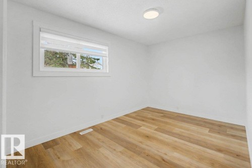 Room featuring wood-finish flooring, white baseboards, a window with blinds, and a flush-mount ceiling light - 49 Galloway Drive, Sherwood Park, AB - Indoor Photo Showing Other Room