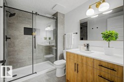 Bathroom featuring a glass-enclosed shower with dark-finish hardware and a built-in recessed niche - 