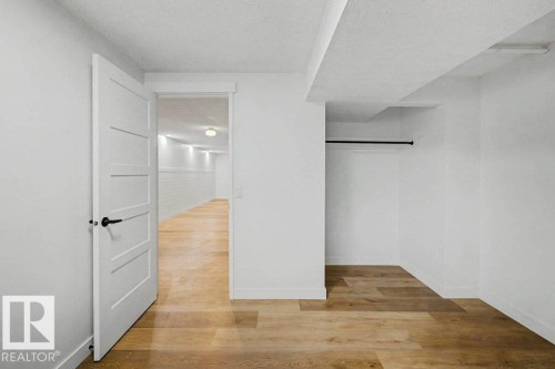 Interior room featuring wood-finish flooring, white walls, and a recessed clothing rod - 49 Galloway Drive, Sherwood Park, AB - Indoor Photo Showing Other Room