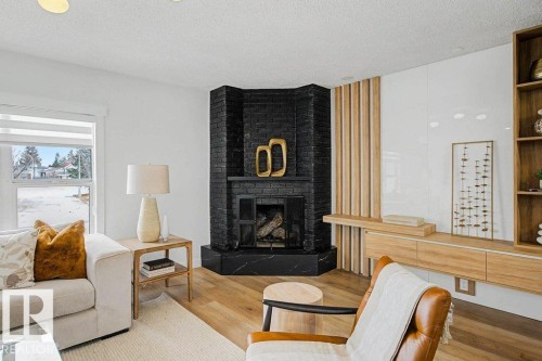Corner fireplace featuring black brick surround and dark stone hearth - 49 Galloway Drive, Sherwood Park, AB - Indoor Photo Showing Living Room With Fireplace