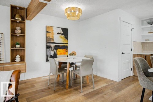 Dining area featuring wood-finish flooring, a contemporary ceiling light fixture, and a built-in shelving unit with lower cabinetry - 49 Galloway Drive, Sherwood Park, AB - Indoor Photo Showing Dining Room