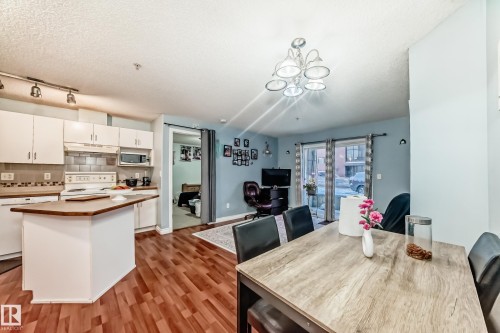 Open-concept living space with wood-finish flooring throughout - 108 10535 122 Street, Edmonton, AB 