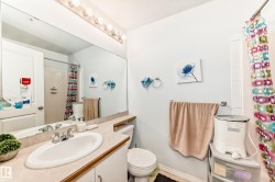 Bathroom featuring a vanity with an integrated sink, a large mirror, and a multi-bulb light fixture - 