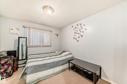 Neutral wall colors with textured ceiling, featuring a window with vertical blinds, and a flush-mount ceiling light fixture - 