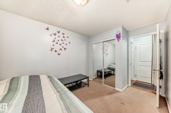 Bedroom featuring wall-to-wall carpeting, mirrored closet doors, and light-colored walls - 
