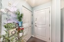 Entryway featuring a white paneled door with brushed nickel hardware, light blue walls, and a textured white ceiling - 108 10535 122 Street, Edmonton, AB 