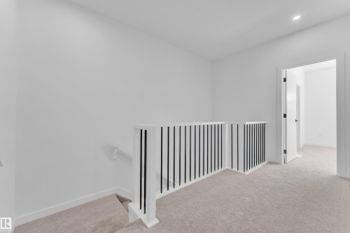 Upper landing featuring plush carpet flooring and modern railing with white balusters and black spindles - 175 Graybriar Drive, Stony Plain, AB 