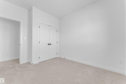Plush neutral-toned carpeting extends throughout this room, complemented by white walls and trim - 175 Graybriar Drive, Stony Plain, AB 