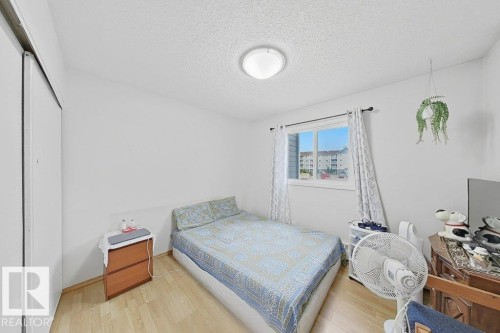 Room featuring light wood-finish flooring, a double-paned window, and a built-in closet with sliding doors - 218 5065 31 Avenue, Edmonton, AB 