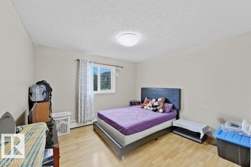 Room featuring wood-finish flooring, a window with natural light, and a ceiling-mounted light fixture - 218 5065 31 Avenue, Edmonton, AB 