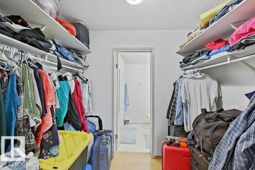 Walk-in closet with ample storage, featuring dual shelving and hanging rods - 218 5065 31 Avenue, Edmonton, AB 