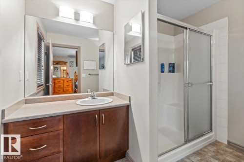 Bathroom featuring a vanity with a light-toned countertop, an integrated sink, and dark wood cabinetry - 229 41 Summerwood Boulevard, Sherwood Park, AB - Indoor Photo Showing Bathroom