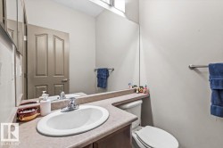 Bathroom featuring an integrated sink, laminate countertop, mirrored wall, and a toilet - 