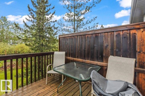 Outdoor deck with natural wood planks, a dark wood privacy fence, and a wooden railing - 229 41 Summerwood Boulevard, Sherwood Park, AB - Outdoor With Deck Patio Veranda With Exterior
