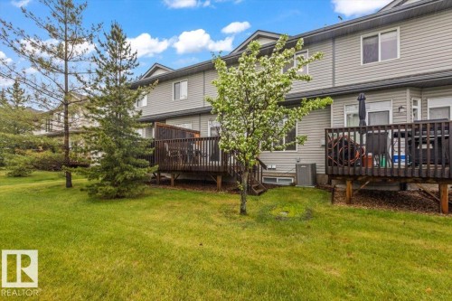 Expansive green lawn providing a natural backdrop to the property - 229 41 Summerwood Boulevard, Sherwood Park, AB - Outdoor With Deck Patio Veranda
