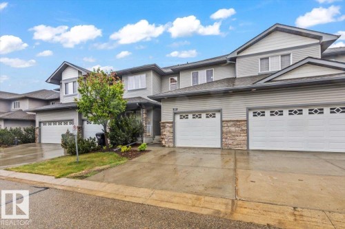 Townhome exterior featuring horizontal siding and stone veneer accents - 229 41 Summerwood Boulevard, Sherwood Park, AB - Outdoor With Facade