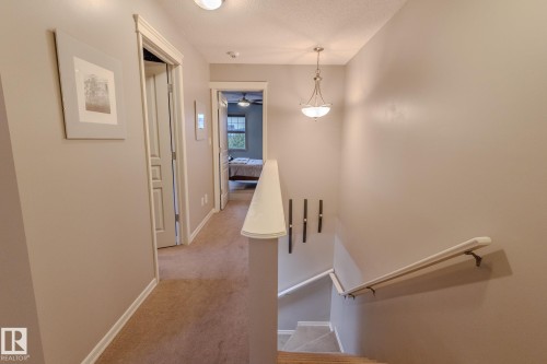 Upper-level hallway featuring carpeted flooring, light neutral wall tones, and white trim - 7207 14A Avenue, Edmonton, AB - Indoor