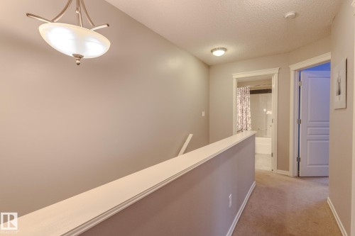 Upper-level hallway with neutral wall paint and carpeted flooring - 7207 14A Avenue, Edmonton, AB - Indoor Photo Showing Other Room