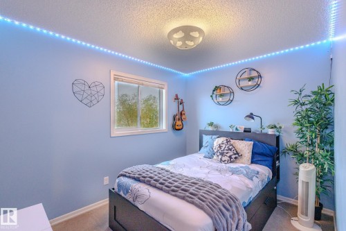 Room featuring light blue walls, a white-framed window, and a textured ceiling - 7207 14A Avenue, Edmonton, AB - Indoor Photo Showing Bedroom