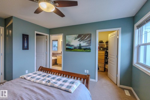 Bedroom featuring a ceiling fan with light fixture, light-colored carpeting, and a window with blinds - 7207 14A Avenue, Edmonton, AB - Indoor Photo Showing Bedroom