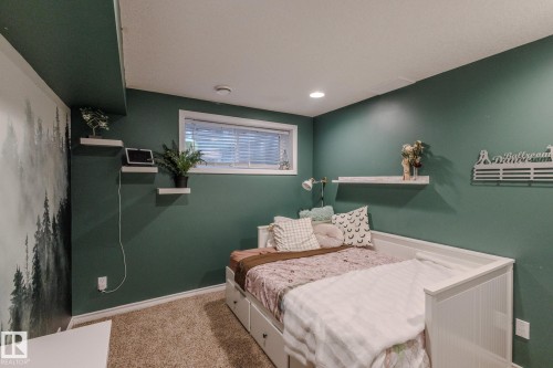 Recessed lighting illuminates the space, featuring a window with blinds, floating wall shelves, and a built-in daybed with drawers - 7207 14A Avenue, Edmonton, AB - Indoor Photo Showing Bedroom