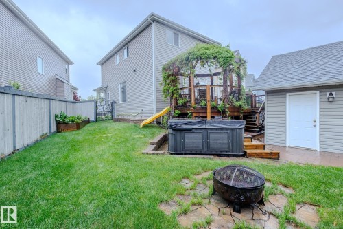 Expansive backyard featuring a large wooden deck with a pergola, a built-in hot tub, and a separate utility shed - 7207 14A Avenue, Edmonton, AB - Outdoor