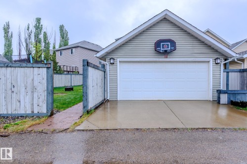 Attached garage with light-toned siding and a white overhead door - 7207 14A Avenue, Edmonton, AB - Outdoor