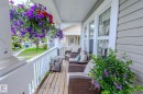 Inviting porch featuring wood-finish flooring, white spindle railing, and a slatted ceiling - 7207 14A Avenue, Edmonton, AB  - Outdoor With Deck Patio Veranda With Exterior 
