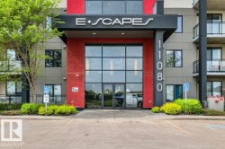 Modern building entrance featuring a prominent black canopy with "E•SCAPES" lettering - 