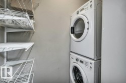 Laundry area featuring a stacked washer and dryer unit, and white wire shelving - 