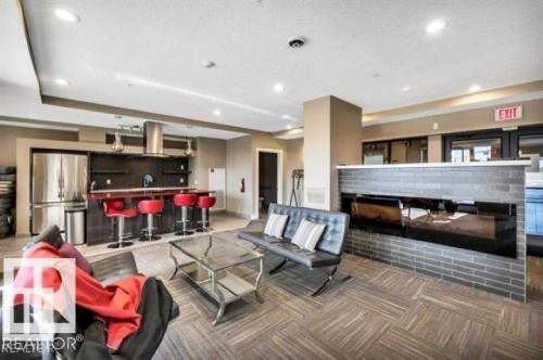 Open-concept space featuring a built-in kitchen area with stainless steel appliances and a breakfast bar - 607 11080 Ellerslie Road, Edmonton, AB - Indoor